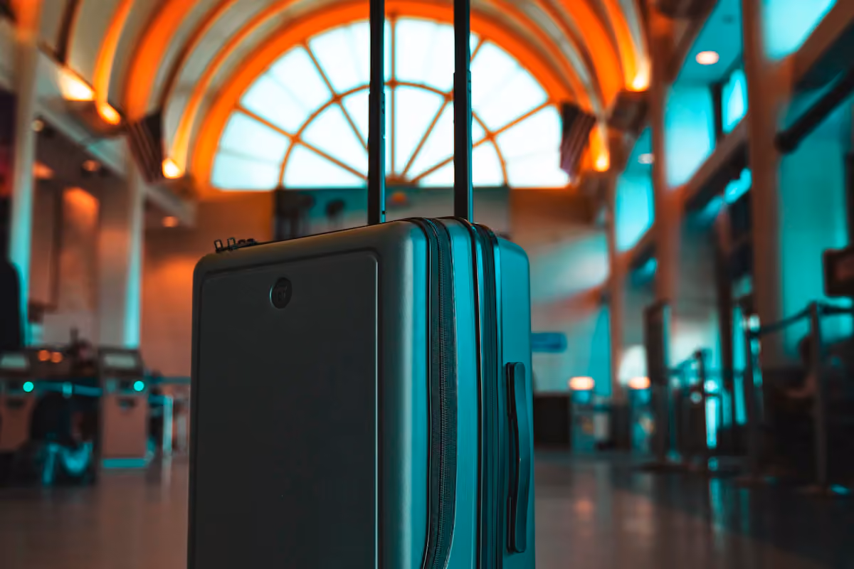 Upright suitcase in a sunlit airport terminal