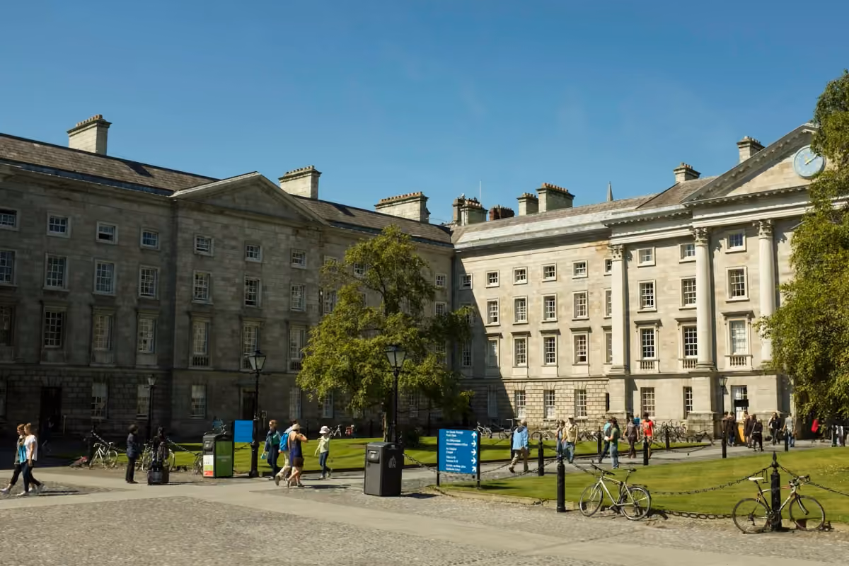 Visitors walking through a courtyard at Trinity College Dublin