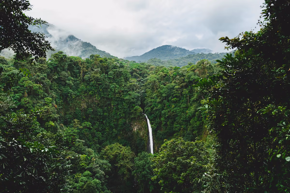 Waterfall beneath dense green rainforest near La Fortuna