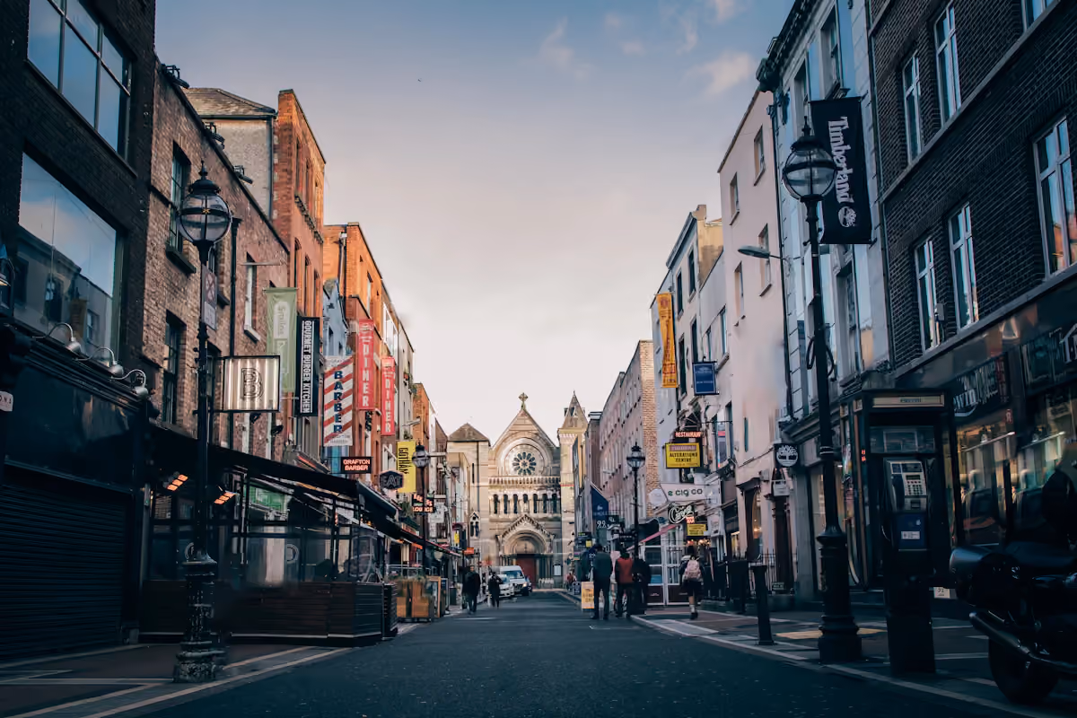 Pedestrians on a central Dublin street with a church ahead