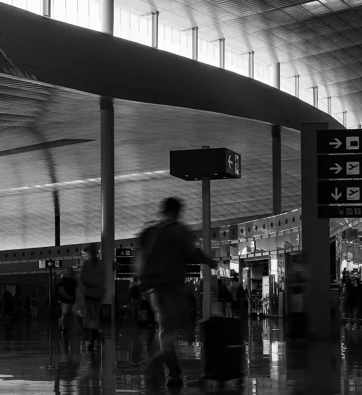 A traveler with luggage in a terminal, photographed with motion blur