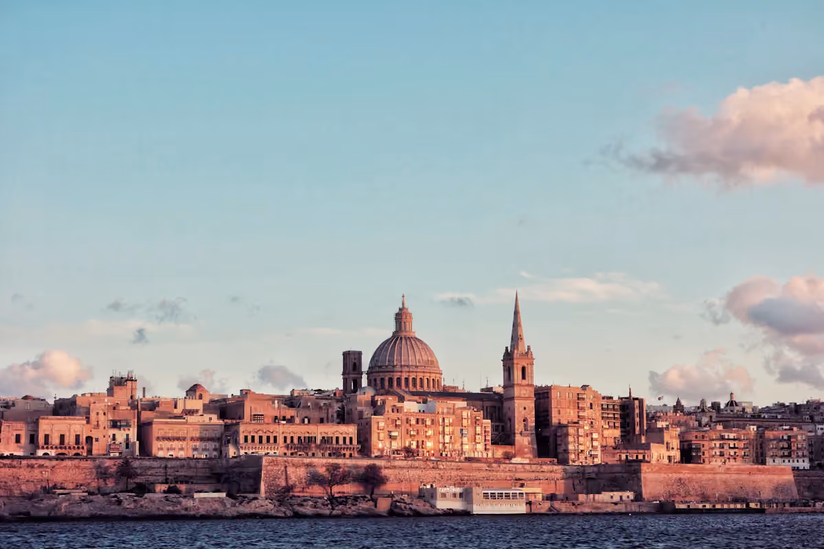Valletta skyline and dome beside the water at sunset