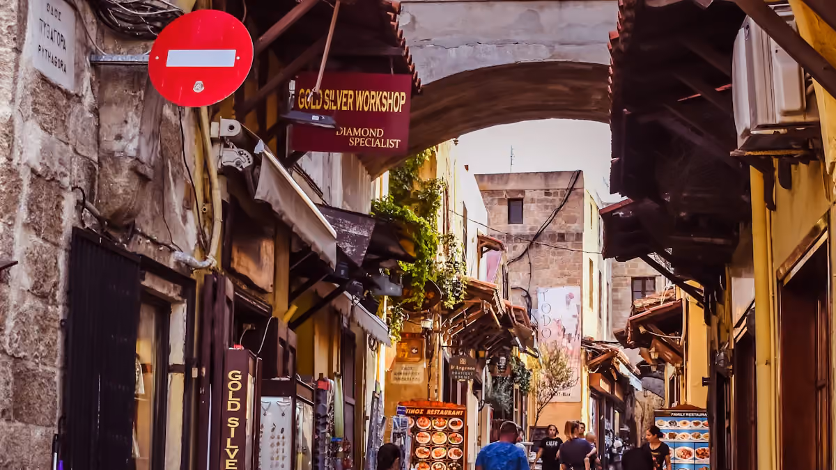Pedestrians on a street lined with shops in Rhodes, Greece