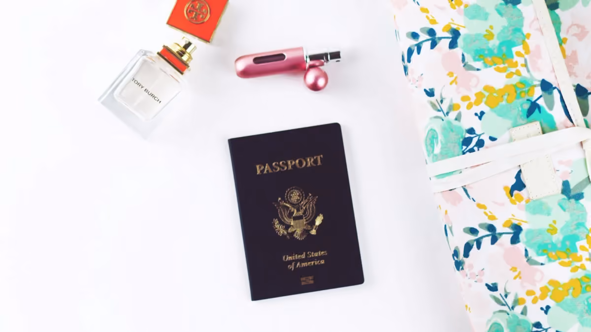 A closed passport arranged with travel accessories on a light surface