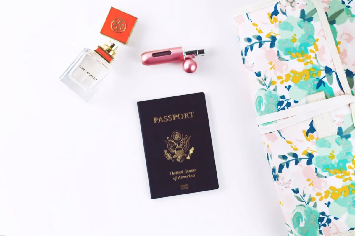 A closed passport arranged with travel accessories on a light surface